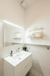 a white bathroom with a sink and a mirror at Happy Home Spazioso Trilocale Bologna a Due Passi Dal Centro in Bologna +37 photos