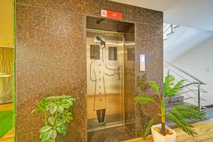 an elevator in a building with a painting on the wall at FabHotel White Ridge Shivam in Hyderabad +24 photos