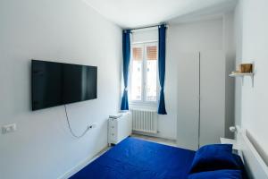 a bedroom with a blue bed and a flat screen tv at Happy Home Spazioso Trilocale Bologna a Due Passi Dal Centro in Bologna