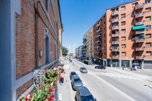 a city street with cars parked on the side of a building at Happy Home Spazioso Trilocale Bologna a Due Passi Dal Centro in Bologna
