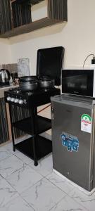a kitchen with a stove and a table with pots and pans at The Unwind Spot Kitengela in Kitengela 
