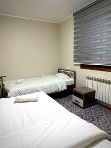 Una cama o camas en una habitación de Cube Guest House OSH