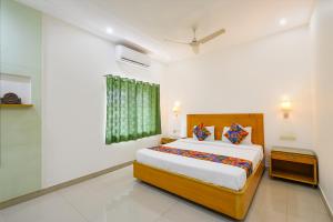 a bedroom with a large bed and a window at FabHotel A&M - Nr LV Prasad Institute, Banjara Hills in Hyderabad