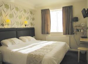 a bedroom with a large bed and a window at The Loudor in Lincoln