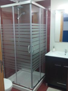 uma cabina de duche em vidro numa casa de banho com lavatório em Casa da Camélia - Sintra em Sintra