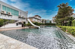 an outdoor swimming pool with a water slide at Veranda Residence By Hello Pattaya in Jomtien Beach