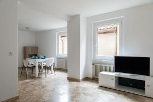 Una sala de estar con un televisor y una mesa. en Rose 2 Apartment by Quokka 360 - duplex on 2 floors with balcony, en Ruvigliana