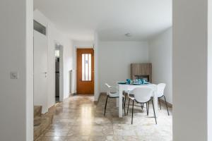 Un comedor blanco con una mesa y sillas blancas. en Rose 2 Apartment by Quokka 360 - duplex on 2 floors with balcony, en Ruvigliana