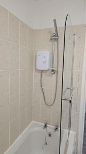 a shower in a bathroom with a bath tub at Two bedroom ground floor sea view apartment in Hastings