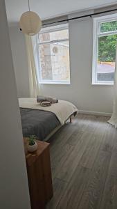 a bedroom with a bed and two windows at Two bedroom ground floor sea view apartment in Hastings +1 photo