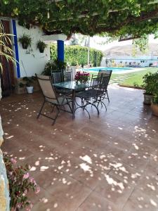 eine Terrasse mit einem Glastisch und Stühlen auf einer Terrasse in der Unterkunft Parada del Herrero casa rural in Zújar
