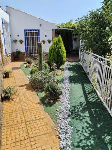 einen Garten vor einem Haus mit einem Zaun in der Unterkunft Parada del Herrero casa rural in Zújar