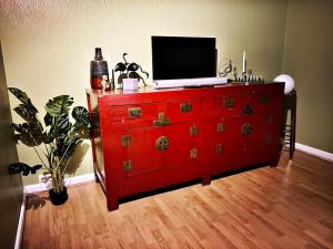 a red dresser with a television on top of it at De Zweverik in Dessel