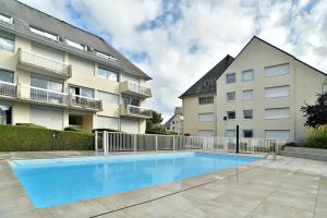 a swimming pool in front of a apartment building at Hygge Castin - Havre de paix, Proche Plage in Saint-Cast-le-Guildo