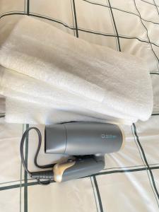 a hair dryer sitting on top of a bed at The Abe Ikebukuro in Tokyo