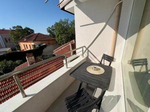 Una mesa de madera y dos sillas en un balcón. en Historic Center Apartment, en Ruse