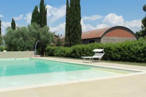 a swimming pool with a chair next to a building at Il Gelsomino Bio Agriturismo in Alberese +15 photos