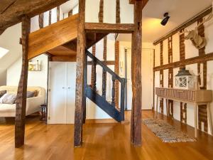 a large room with wooden beams and a staircase at Beau duplex en centre-ville proche cathédrale in Chartres