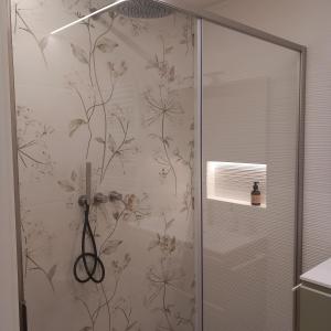 a shower in a bathroom with floral wallpaper at Riflessi sul lago in Baselga di Pinè +35 photos
