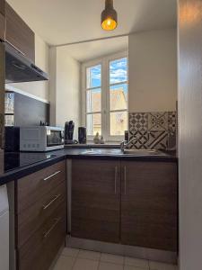 a kitchen with a sink and a microwave at Beau duplex en centre-ville proche cathédrale in Chartres +6 photos