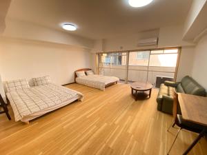 a room with two beds and a couch and a table at The Abe Ikebukuro in Tokyo
