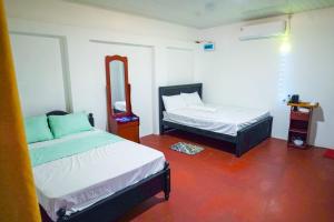 a room with two beds and a mirror at The garlic Restaurant & Lodge in Habarana