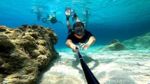 a man in the water with a snorkel and a diver at iCampJal Beach Camp and Bar in Jal