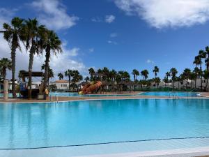 a large swimming pool with a slide in a resort at Confortable Apartment in Corralejo in Corralejo