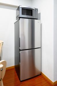 a silver refrigerator with a microwave on top of it at Near Shibuya Station 4Beds 5Max A175 in Tokyo