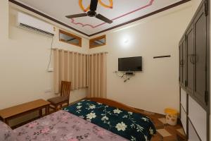 a bedroom with a bed and a flat screen tv at Sudama Dham Homestay in Ayodhya