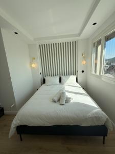 a bedroom with a large white bed with two towels on it at RIVIERA - 2 Pièces de Charme - Vue Lac - Clim - Parking in Annecy