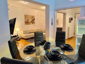 a living room with a glass table and black chairs at Central Glyfada 2BR Apartment in Athens +24 photos
