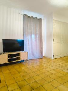 a living room with a flat screen tv on a cabinet at Auravignon in Sorgues +14 photos