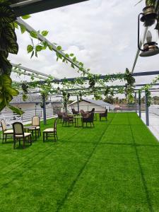 a patio with chairs and tables on the grass at HK Resort 