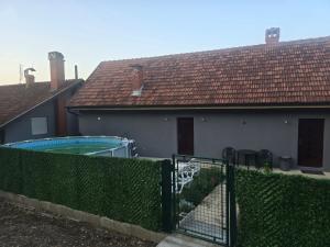 a house with a swimming pool and a fence at Zuto brdo Batinac 