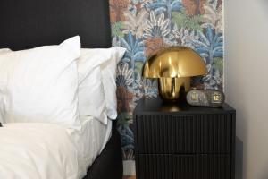 a bedroom with a bed and a clock on a night stand at Ellipse Olive and Vine in Midrand