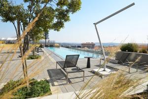 a pool with chairs and a table with a view at Ellipse Olive and Vine in Midrand