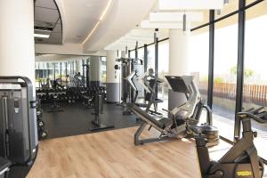 a gym with treadmills and exercise bikes in a room at Ellipse Olive and Vine in Midrand