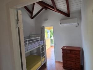 ein Schlafzimmer mit einem Etagenbett und einer Holzkommode in der Unterkunft ÉLÉGANT APPARTEMENT À LA CAMPAGNE in Sainte-Anne