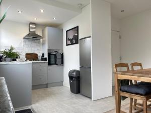 a kitchen with a stainless steel refrigerator and a table at Spacious home in Woodhouse sleeps 9 guests! in Central Station +12 photos