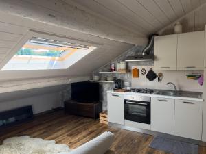 a kitchen with a sink and a stove in a room at Terrazzo Panoramico - Vicino ad Asiago in Roana