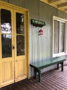 a house with a green bench on the front porch at la casa en el rio II in Tigre