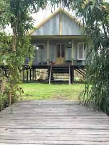 a house with a wooden walkway in front of it at la casa en el rio II in Tigre