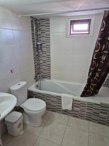 a bathroom with a toilet and a tub and a sink at Myriama Apartments in Ayia Napa +30 photos