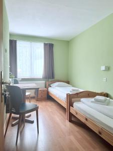 比维奥Hotel Guidon Zimmer的一间卧室，有两张床、一张书桌和一张桌子