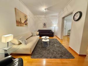 a living room with a couch and a clock on the wall at Central Glyfada 2BR Apartment in Athens