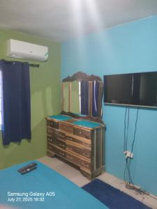 a room with a tv and a dresser in a room at Cheerful Private Bedroom with AC in Falmouth
