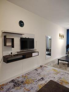 a living room with a flat screen tv on a wall at Tamara Homestay 4BR Cozy Stay in Jerantut +14 photos
