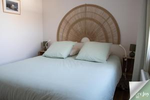 a bedroom with a large white bed with a wooden headboard at Logis Robin in Agon Coutainville