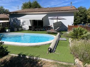 a swimming pool in the yard of a house at Cocooning chez Sabine in La Ville Dieu du  Temple